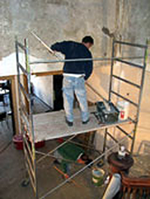 detail of plasterer on scaffolding repairing walls